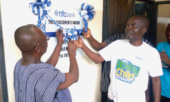 Mr John Botbil Kobiga (right), the Tamale Branch Manager of the HFC bank, and Pastor Adjei-Mensah (left) unveiling the plaque to mark the handing over ceremony of the children’s ward.